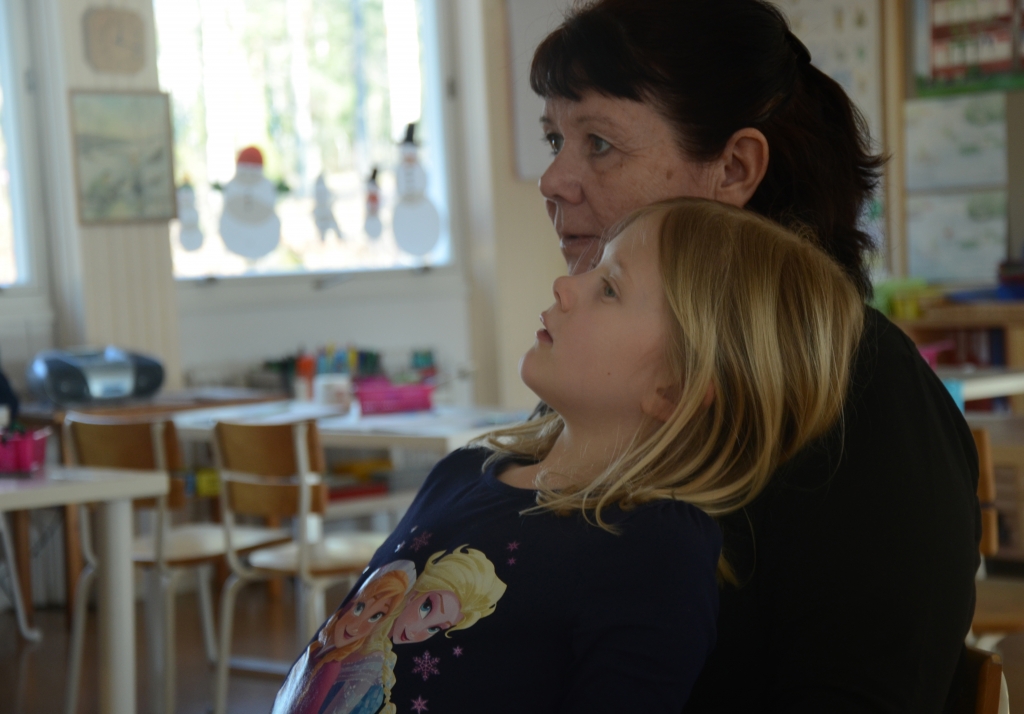 Lärare med elev i knät