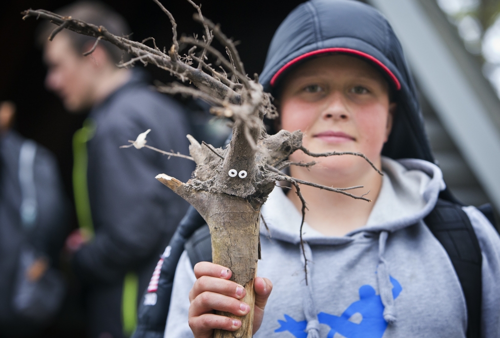 Elev håller upp en pinne med häftstiftsögon