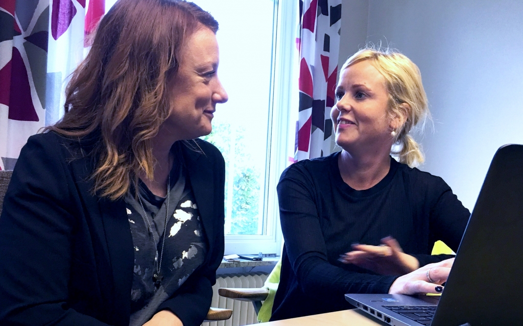 En pedagogista och en specialpedagog arbetar framför en laptop och tittar på varandra