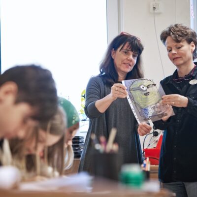 Klasslärare och skolkonstnär tittar på en teckning