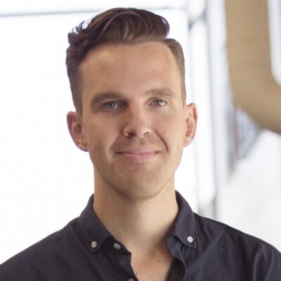 Andreas Borg, forskare, brunt hår, svart skjorta, leende. Närbild med ljus bakgrund.