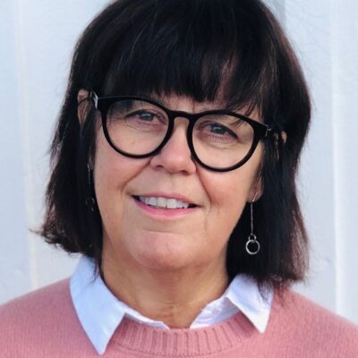 Anette Forssten Seiser i rosa tröja, mörkt hår och glasögon med svarta bågar