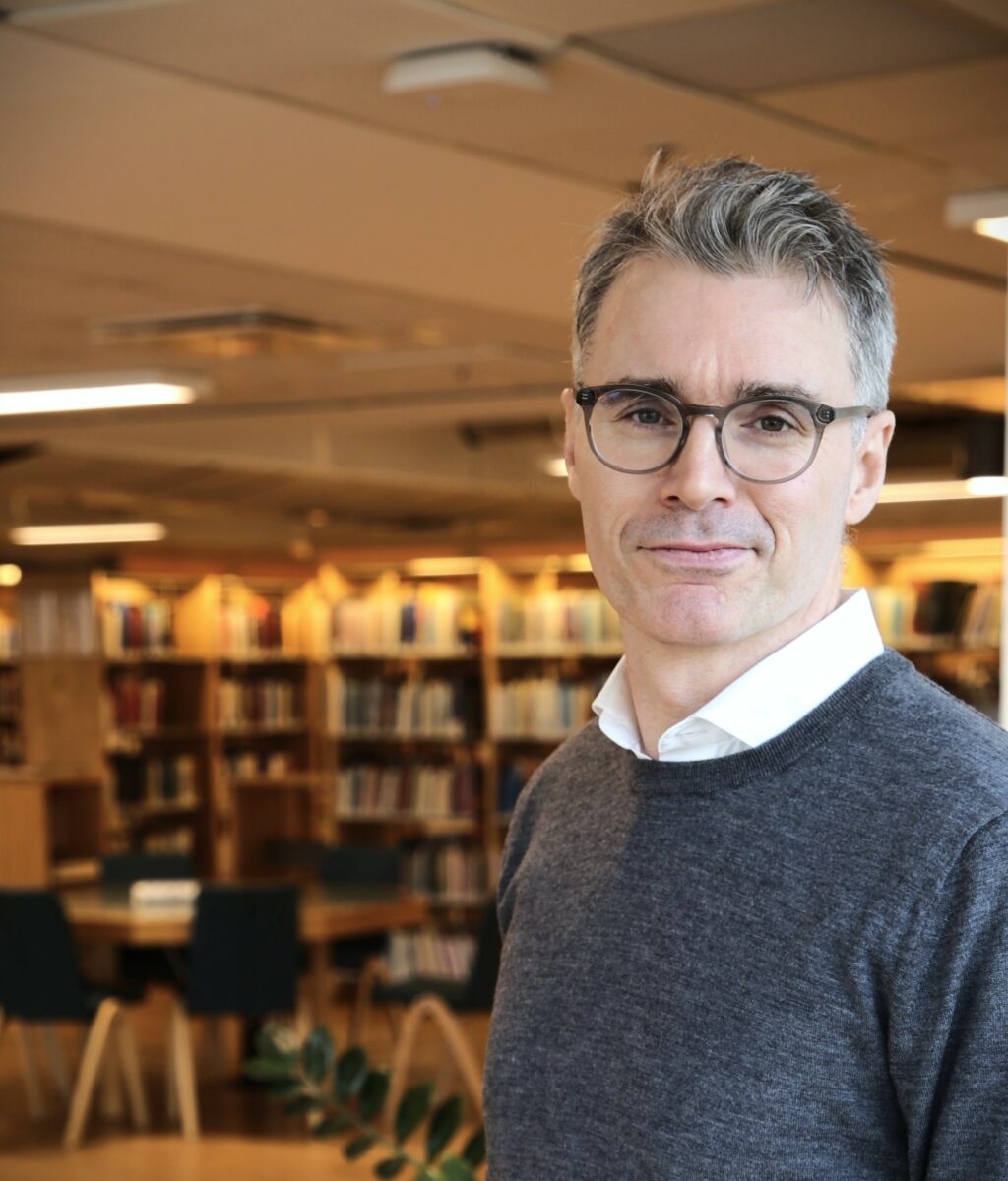Bild på Stig-Börje Asplund i ett bibliotek.